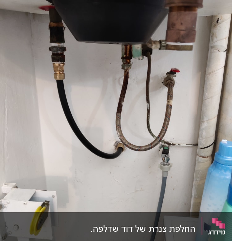צינורות מתכת וגומי מתחת לכיור עם ברזים